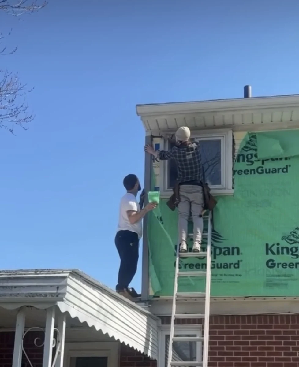 Crew working on exterior trim beside an upper-story window