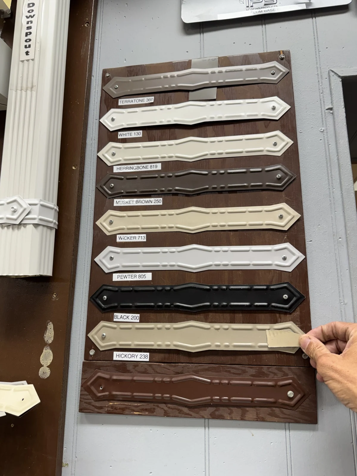 Display of downspout straps in several finish colors