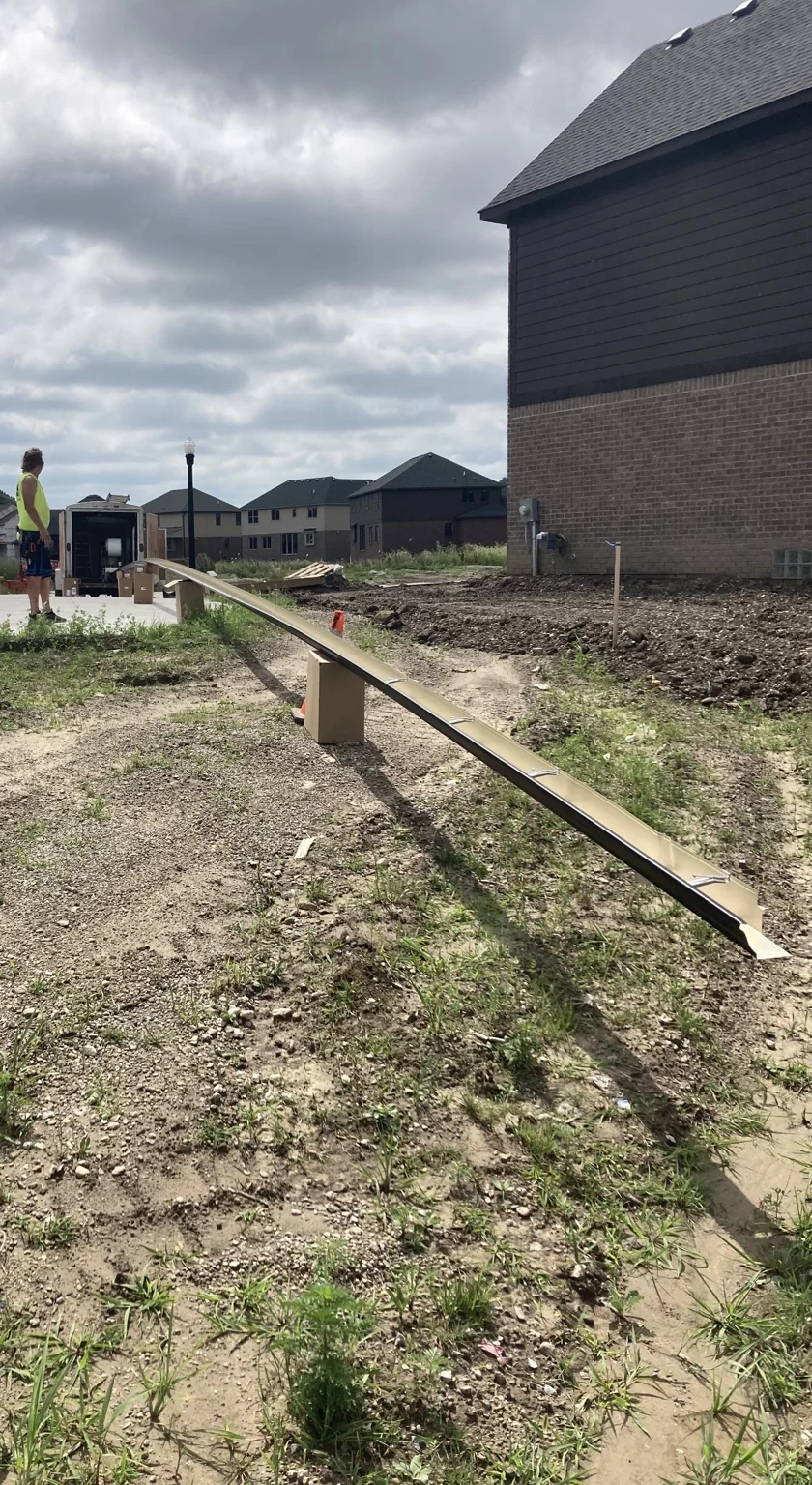 Long seamless gutter run prepared beside a home