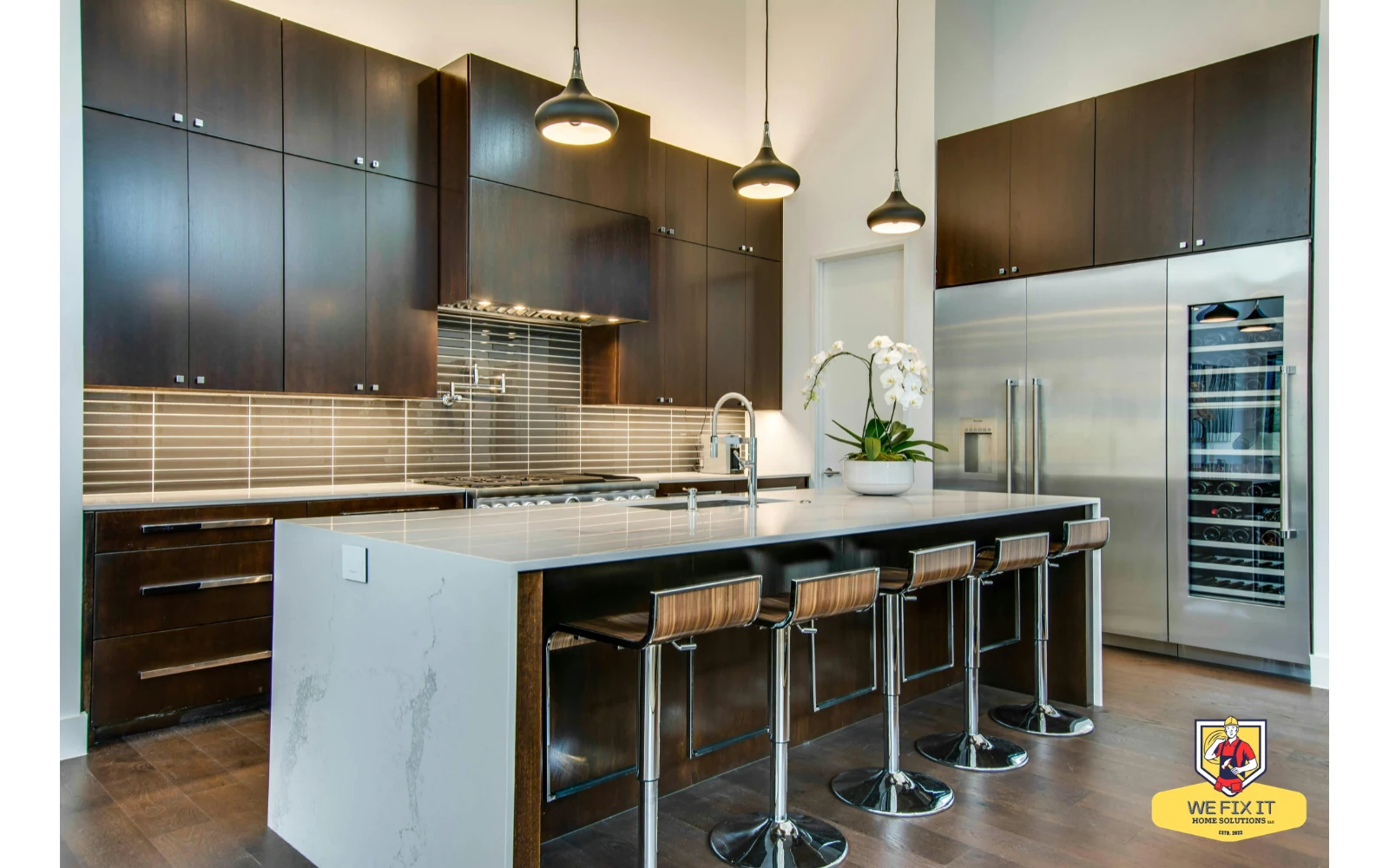 Kitchen with dark cabinetry, pendant lights and a large island