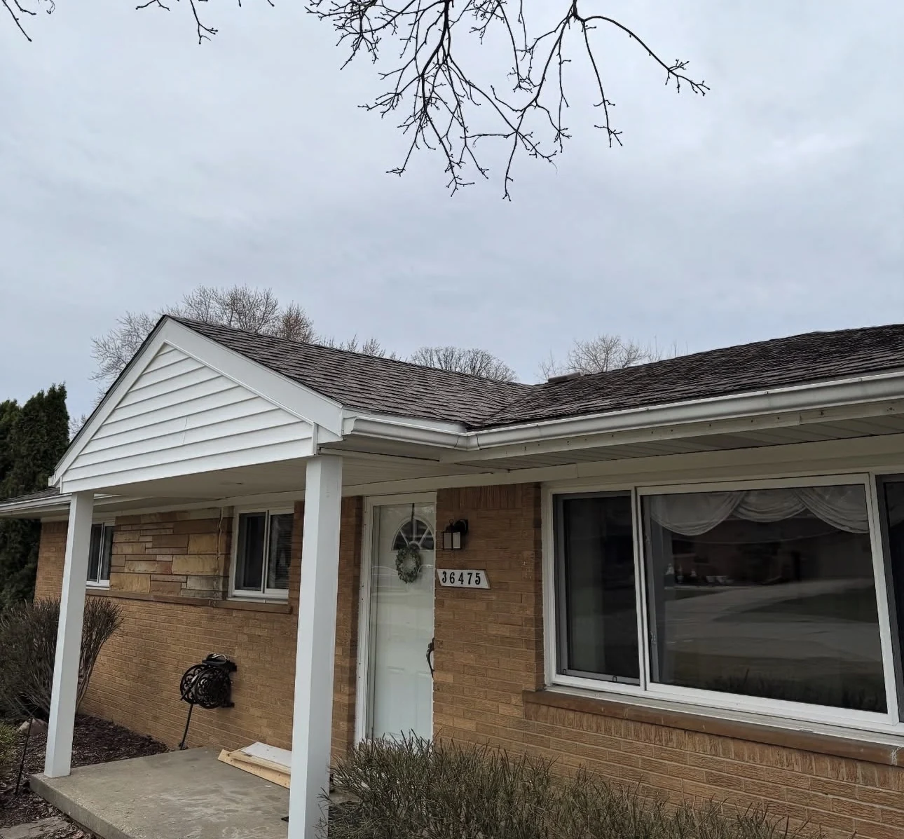 Front porch with white posts, gable siding and exterior trim