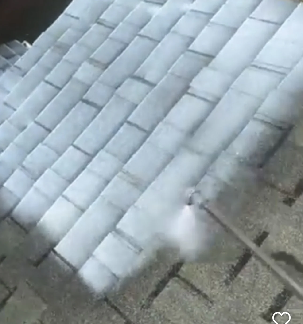 Spray application in progress on roof shingles