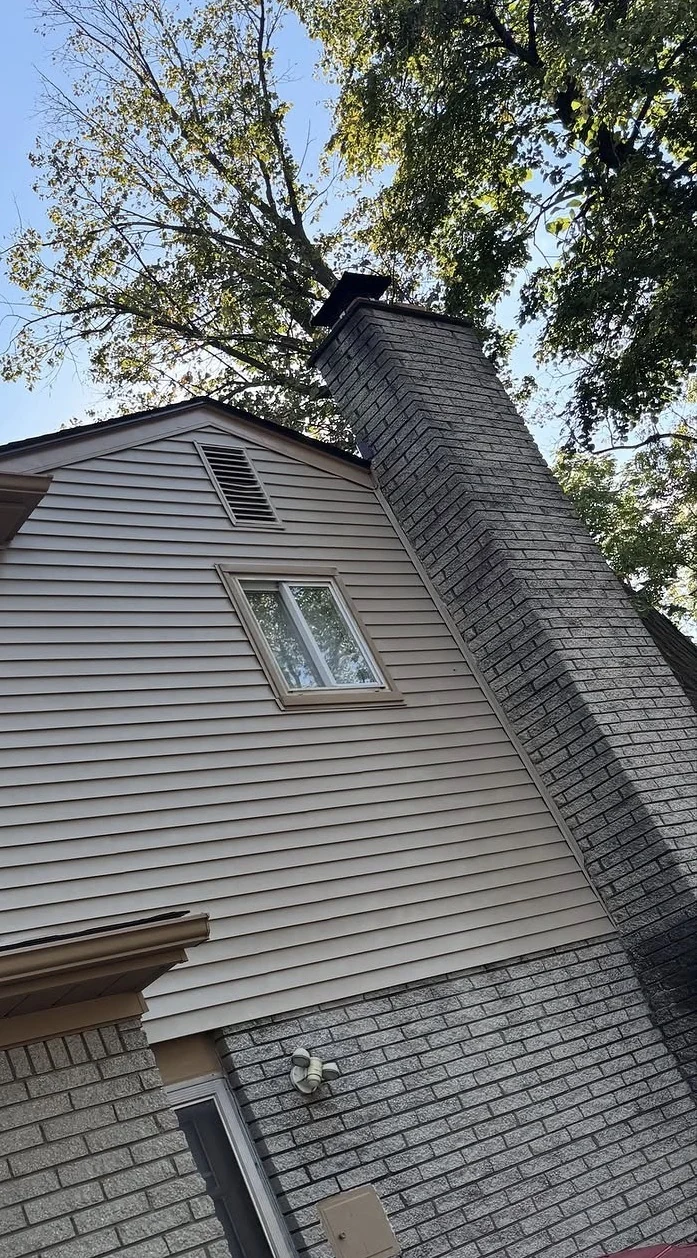 Home exterior with horizontal siding beside a masonry chimney