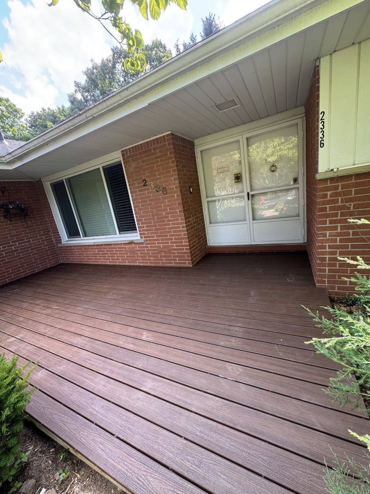 Completed brown Trex composite porch decking at a home entrance