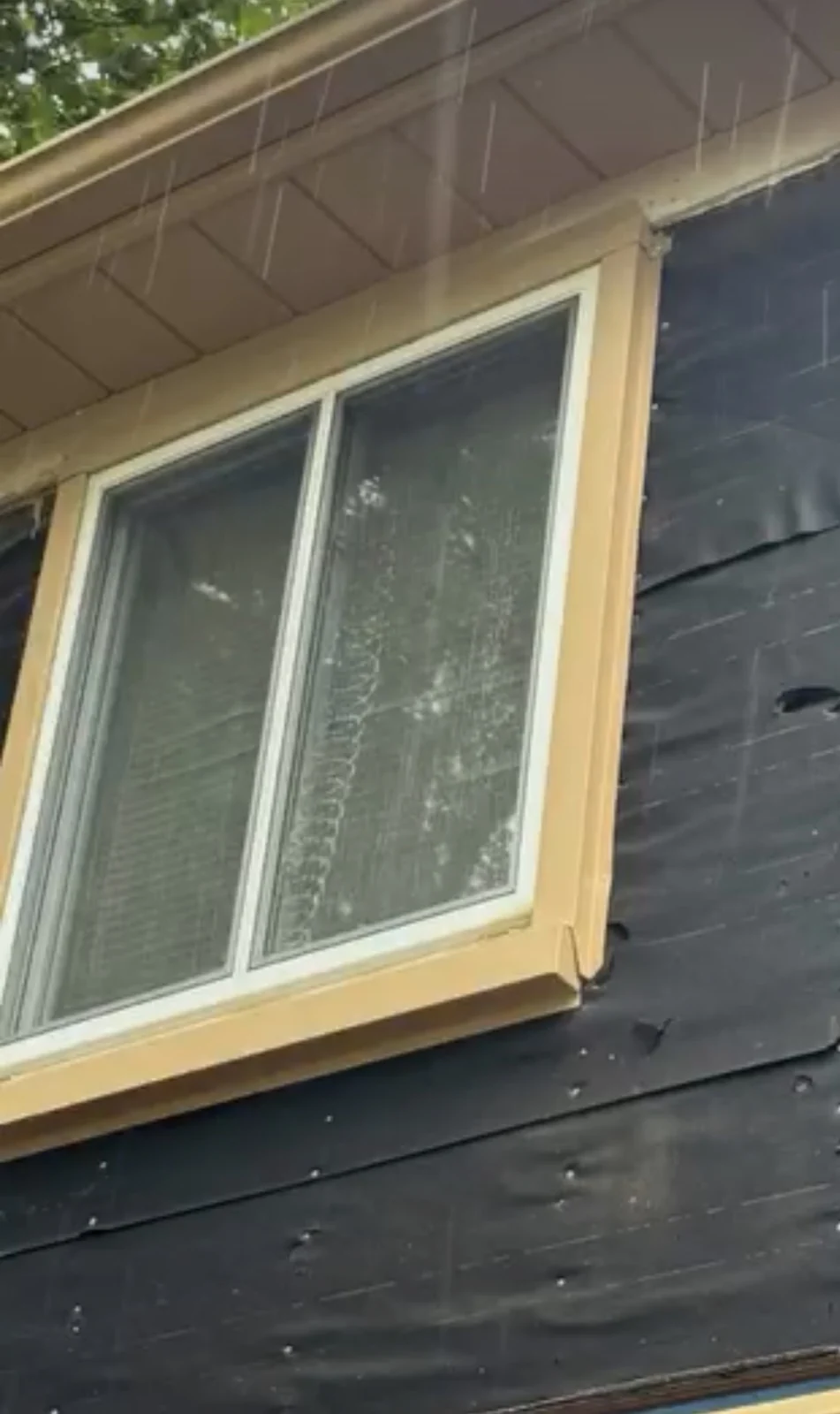 Window with wood trim and exposed exterior wall during work