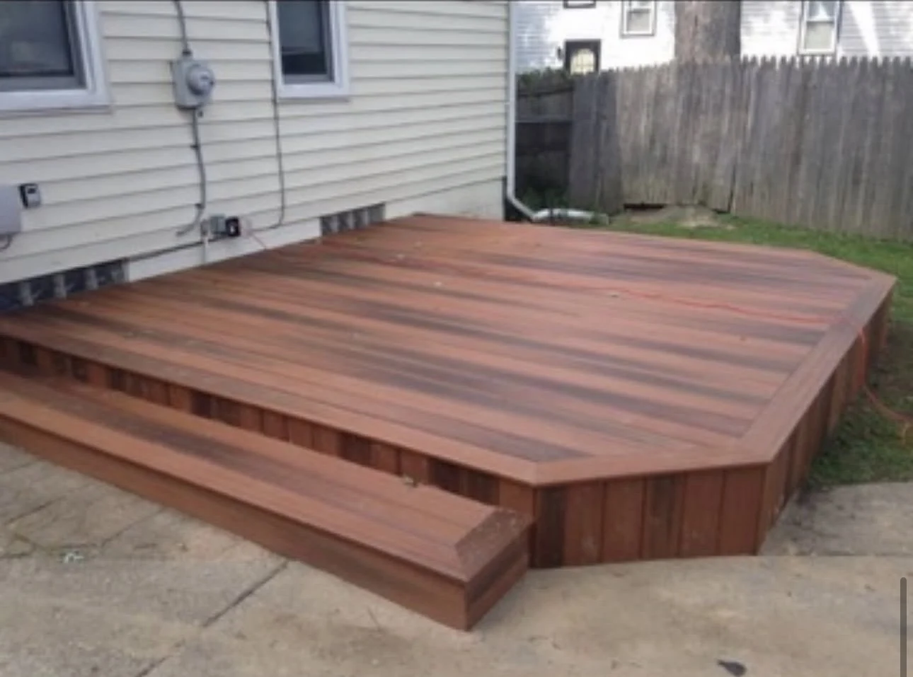 Composite deck with a wide step beside a home
